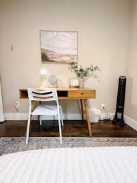 a white desk in a bedroom with a fan